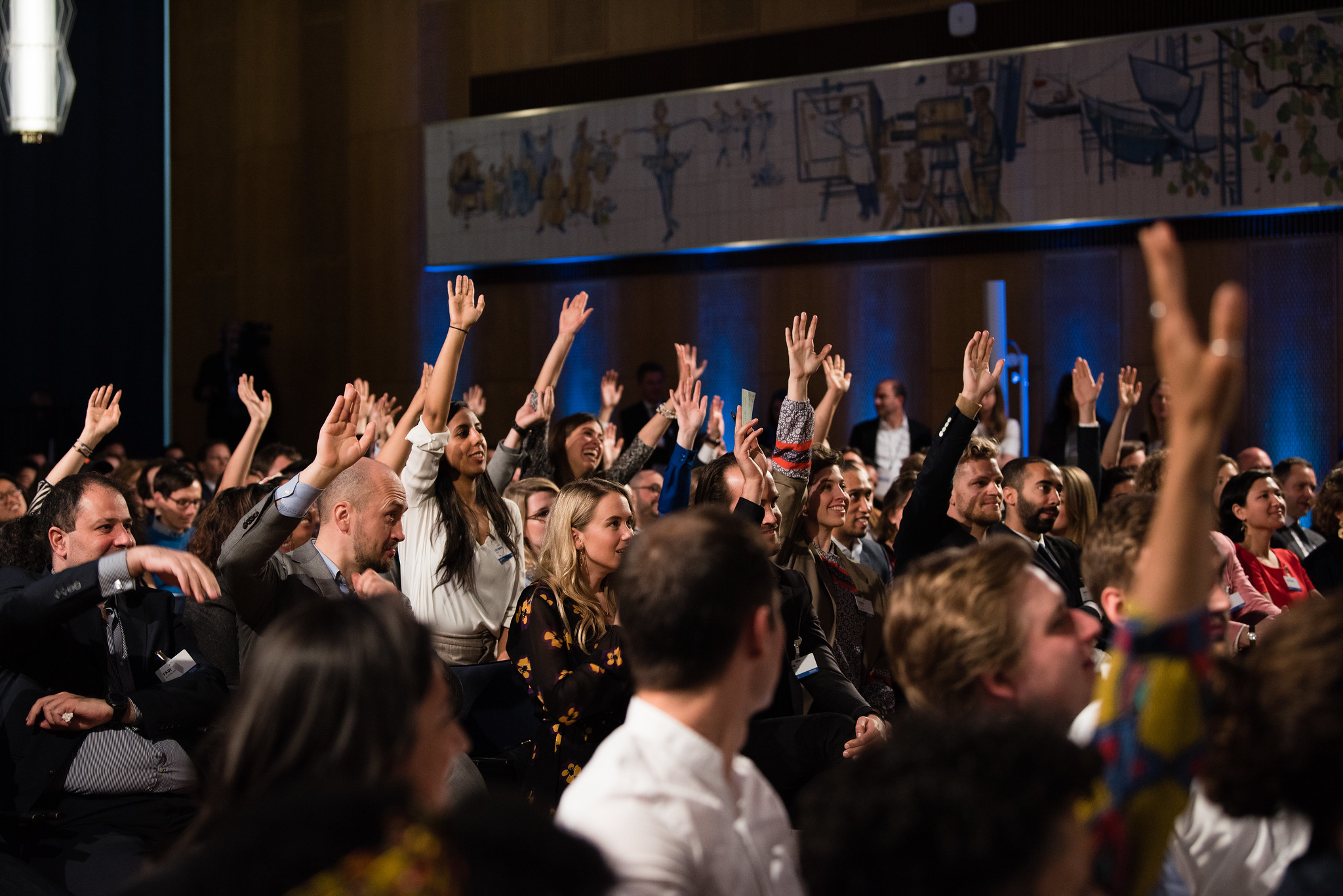 People raising their hands at President Barack Obama's town hall event at ESMT Berlin